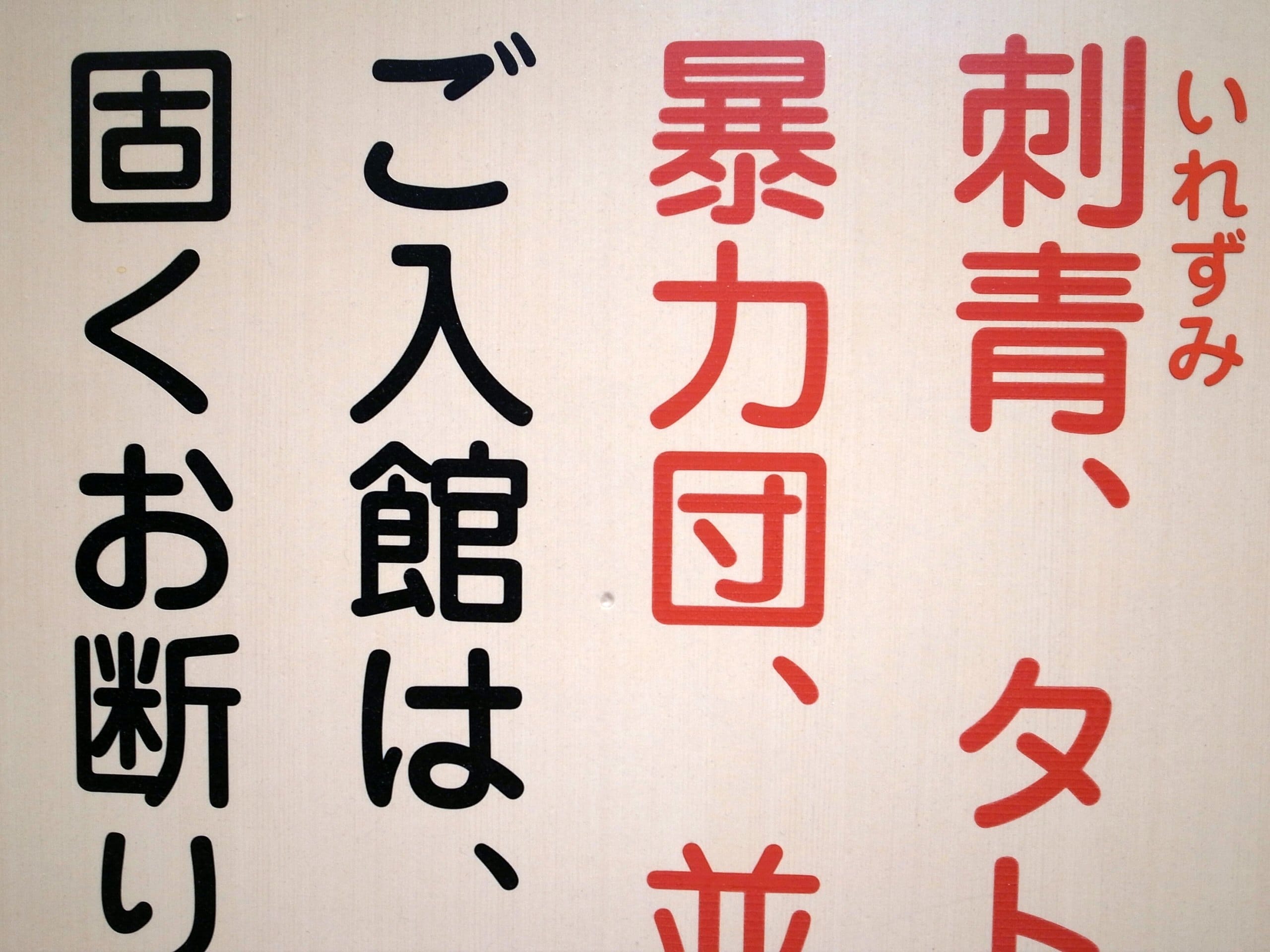 Close-up of a Japanese bath notice refusing entry to people with tattoos or gang ties
